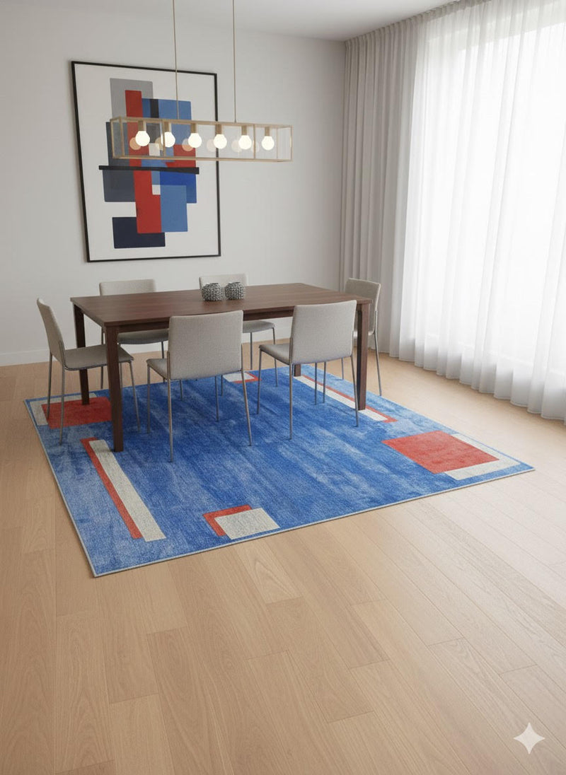 8' x 8' square blue geometric contemporary area rug placed beneath a modern dining table with light upholstered chairs and abstract wall art.