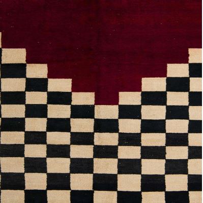 Angled close-up view of the 6' x 9' Abstract Dark Almond Brown Modern Area Rug highlighting the bold checkerboard pattern, contrasting deep red abstract section, and textured contemporary design.