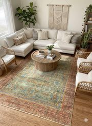 Large brown and teal distressed medallion area rug styled in a living room with a sectional sofa, rattan chairs, and a round wooden coffee table.