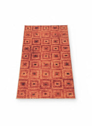Rectangular rug featuring a repeating square geometric pattern in burnt orange and rust brown tones.