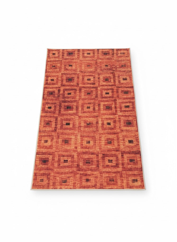 Rectangular rug featuring a repeating square geometric pattern in burnt orange and rust brown tones.
