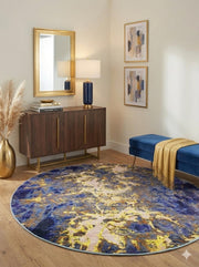 Round navy blue, gold, and cream abstract area rug styled in an entryway with a wooden console table, gold mirror, and blue bench.